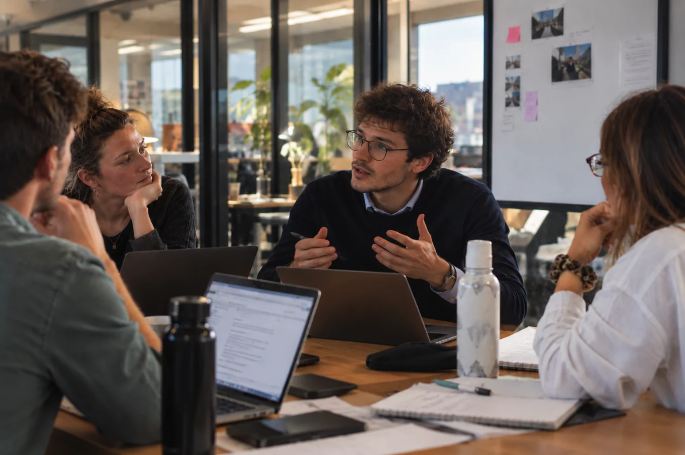 Étudiants en MBA échangeant autour d'une table de travail lors d'une réunion de stratégie